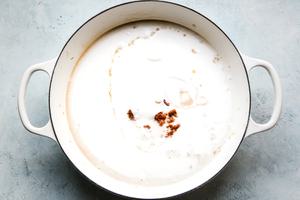 coconut milk with curry paste in a large white skillet