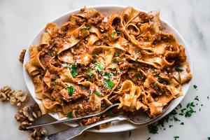Walnut Vegan Bolognese with lentils with pasta on a plater with a serving spoon