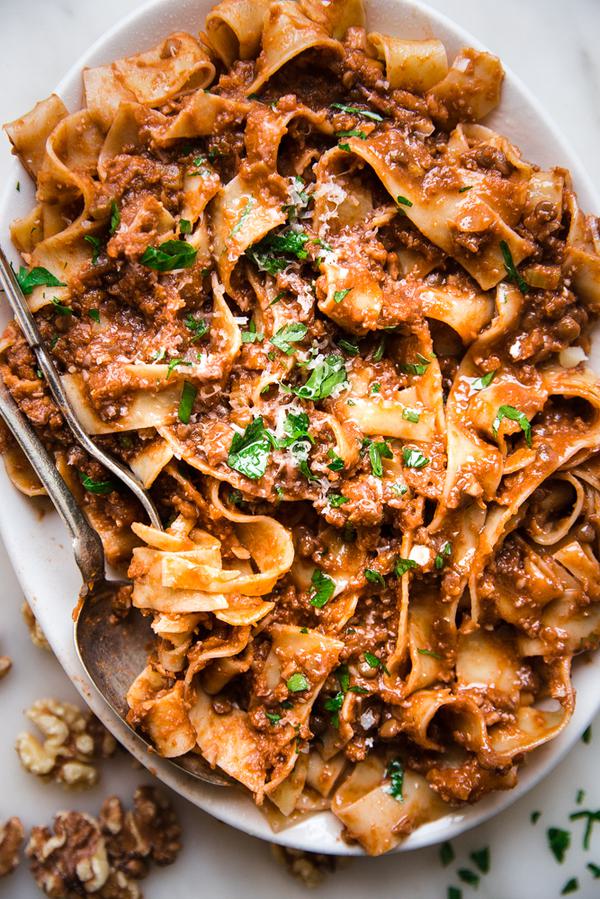 Walnut Vegan Bolognese with lentils with pasta on a plater with a serving spoon