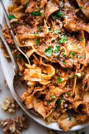 Walnut Vegan Bolognese with lentils with pasta on a plater with a serving spoon