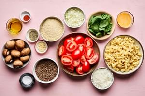 ingredients laid out for vegetarian meatballs along with fresh roma tomatoes and olive oil are set aside for roast tomatoes