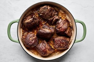 large pieces of slated chuck roast being browned in olive oil in a large pot