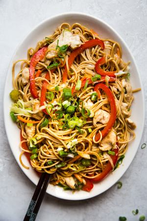 homemade chicken chow mein with bell peppers, celery, carrots on a serving plate