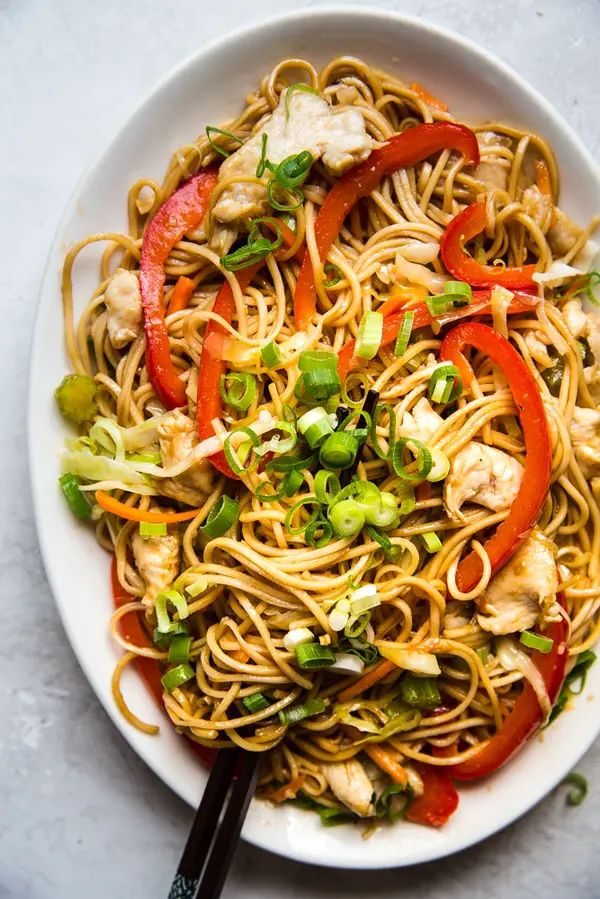 homemade chicken chow mein with carrots, cabbage, celery and green onion on a plate
