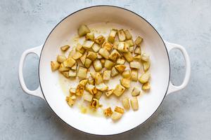 diced potatoes being cooked in olive oil in a large skillet