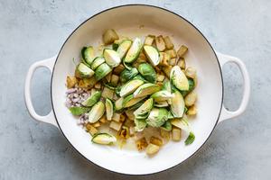 diced potatoes and brussels sprouts being cooked in olive oil in a large skillet