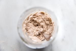 Bubbly sourdough starter in a glass jar with visible rise and fermentation bubbles along the sides.