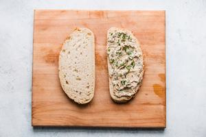 two slices of sourdough bread with herbed mayo spread on one side.