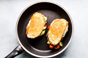 Two grilled chicken sandwiches shown in a black skillet.