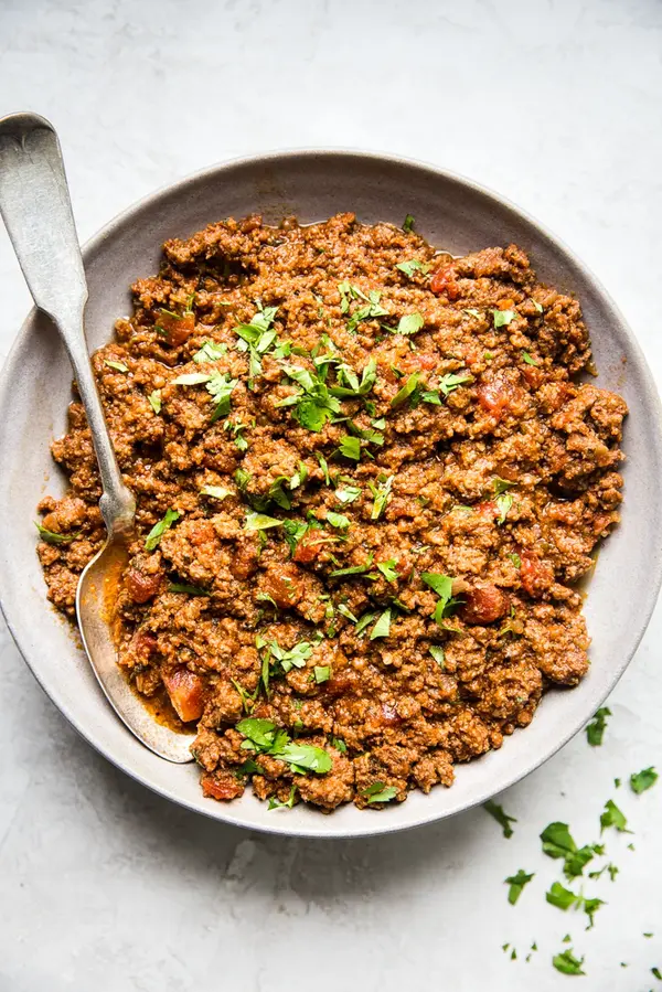 Crock pot taco meat in a bowl with spoon