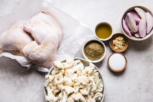 raw chicken legs, cauliflower, za'atar, shallots, garlic, salt and olive oil in small bowls