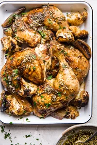 Chicken leggs with za'atar and cauliflower roasted on a sheet pan with fresh parsley