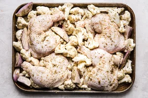 chicken, cauliflower and shallots on a sheet pan
