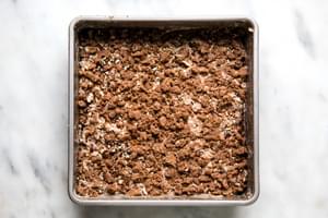 homemade apple crumb cake batter topped with apples and crumb topping in a baking pan ready for the oven
