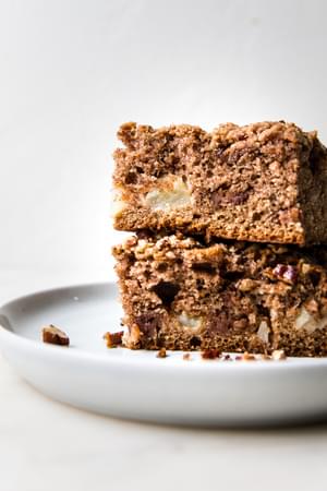 two slices of apple crumb cake stacked on top of each other on a plate