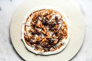 pizza dough topped with bbq sauce, cheese, chicken and caramelized onions.