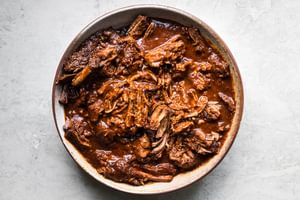 a bowl of homemade shredded beef birria on the counter