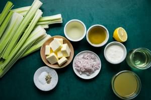 leeks, butter, salt, pepper, white wine, white wine vinegar, cream, olive oil, and chicken stock in bowls on the counter