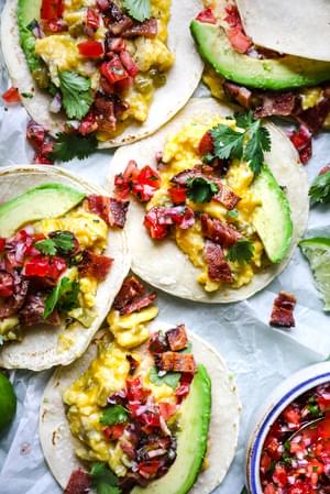 homemade breakfast tacos with green chilis, bacon, avocado, cheddar cheese and salsa