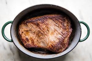 seasoned beef brisket being browned in a dutch oven