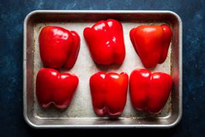 6 red pepper halves on a baking sheet with olive oil