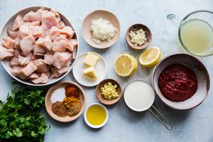 onion, garlic, ginger, butter, stock tomato paste, spices, chicken, and cream in prep bowls to make butter chicken