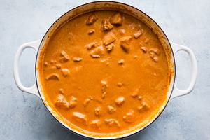a pot of butter chicken made with garlic, ginger, stock tomato paste, cinnamon, cumin, garam masala, cumin and cream