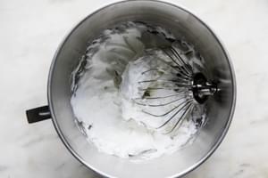 whipped egg whites with medium peaks in a bowl