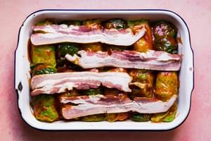 Polish cabbage rolls stuffed with ground beef, sausage & rice, topped with ketchup and bacon ready to be baked to perfection