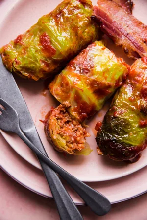 Warm Polish cabbage rolls stuffed with ground beef, sausage and rice, baked to perfection, topped with ketchup & crisp bacon.