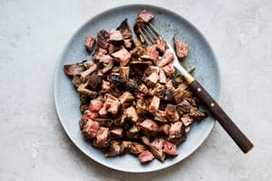 homemade carne asada cut up on a plate with a fork