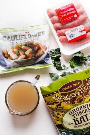 cauliflower gnocchi, chicken broth, chicken Italian sausage and kale on the counter for cauliflower gnocchi Zuppa Toscana