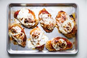 pan fried breaded chicken breast then baked topped with marinara and mozzarella on a baking sheet