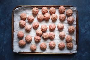 raw Chimichurri Meatballs on a baking sheet with parchment