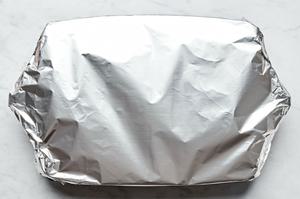 lasagna in a baking dish covered in foil ready to go in the oven