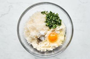 ricotta, egg, Parmesan, basil, salt and pepper being combined in a bowl