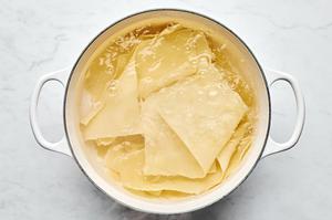 lasagna noodles being boiled in a pot of water