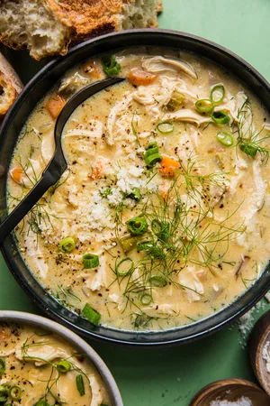 homemade creamy chicken soup in a bowl with a spoon served with crusty bread