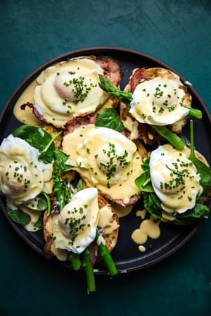 eggs benedict with hollandaise sauce on English muffins with ham and asparagus and poached eggs