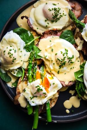 eggs benedict with hollandaise sauce on English muffins with ham and asparagus and poached eggs