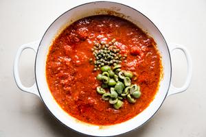 puttanesca sauce with butter, garlic, anchovies white wine, salt, pepper, capers and olives in a braising dish