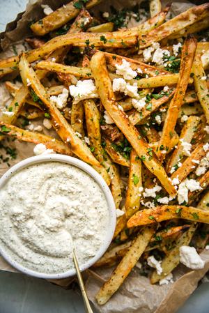 homemade Greek Fries (Patates Tiganites) with feta dip on a plate