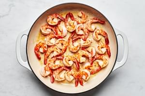 shrimp being cooked in a skillet with olive oil