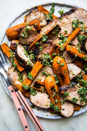 Grilled Pork Tenderloin with Carrots and Chermoula on a plate with a fork and knife