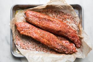raw pork tenderloin rubbed with spices on a baking sheet