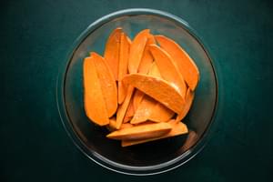 potato wedges in a bowl with olive oil