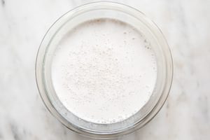 a glass bowl full of homemade almond milk sitting on the counter