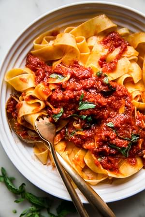 cooked egg noodles topped with Homemade Marinara Sauce in a bowl with basil