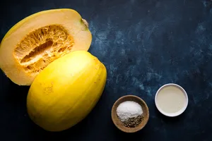 spaghetti squash, salt, pepper and olive oil in prep bowls to explain how to cook a spaghetti squash