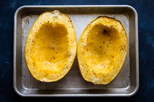 oven roasted spaghetti squash seasoned with salt and pepper on a baking sheet